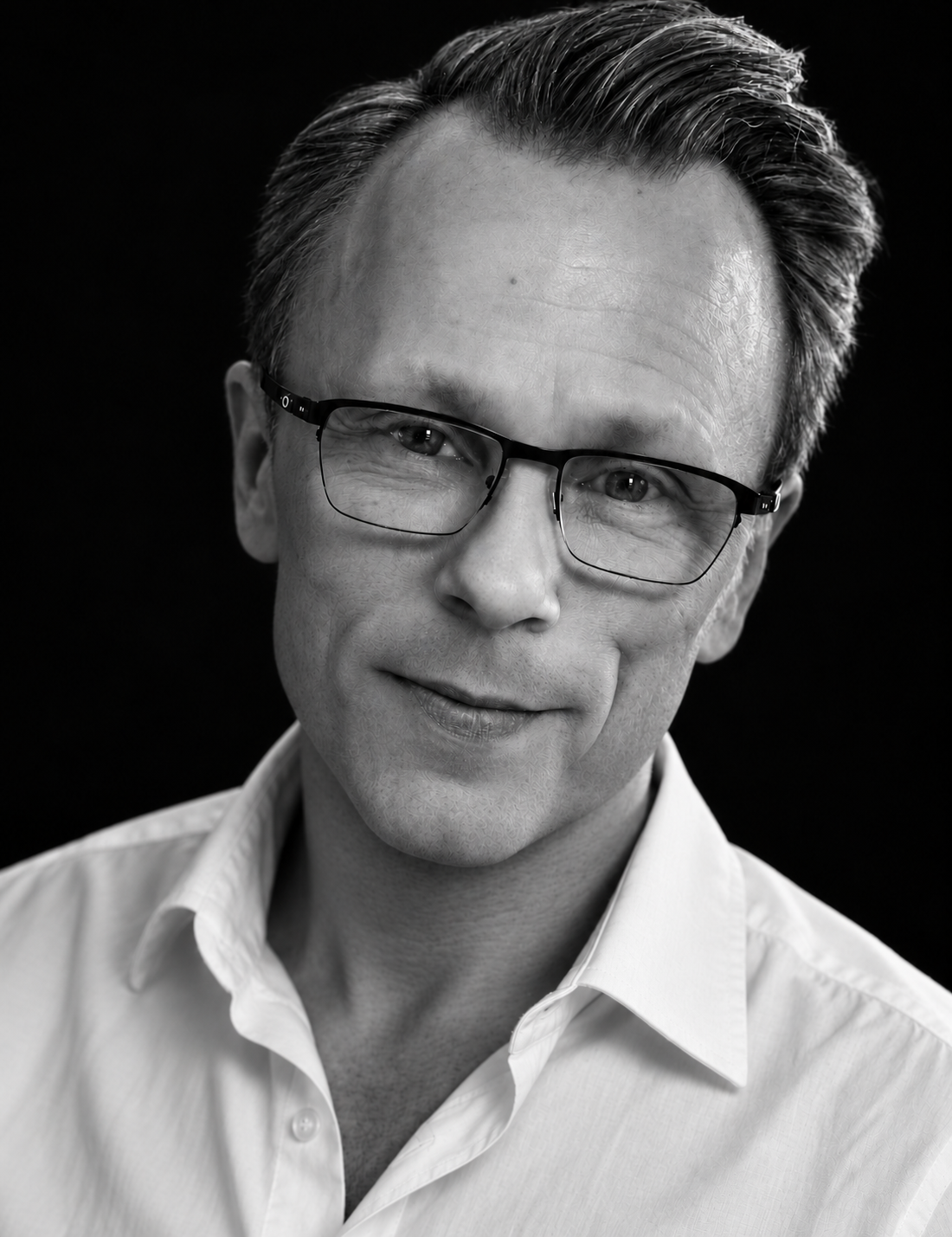 Andreas Svensson wearing a white shirt against a black studio background